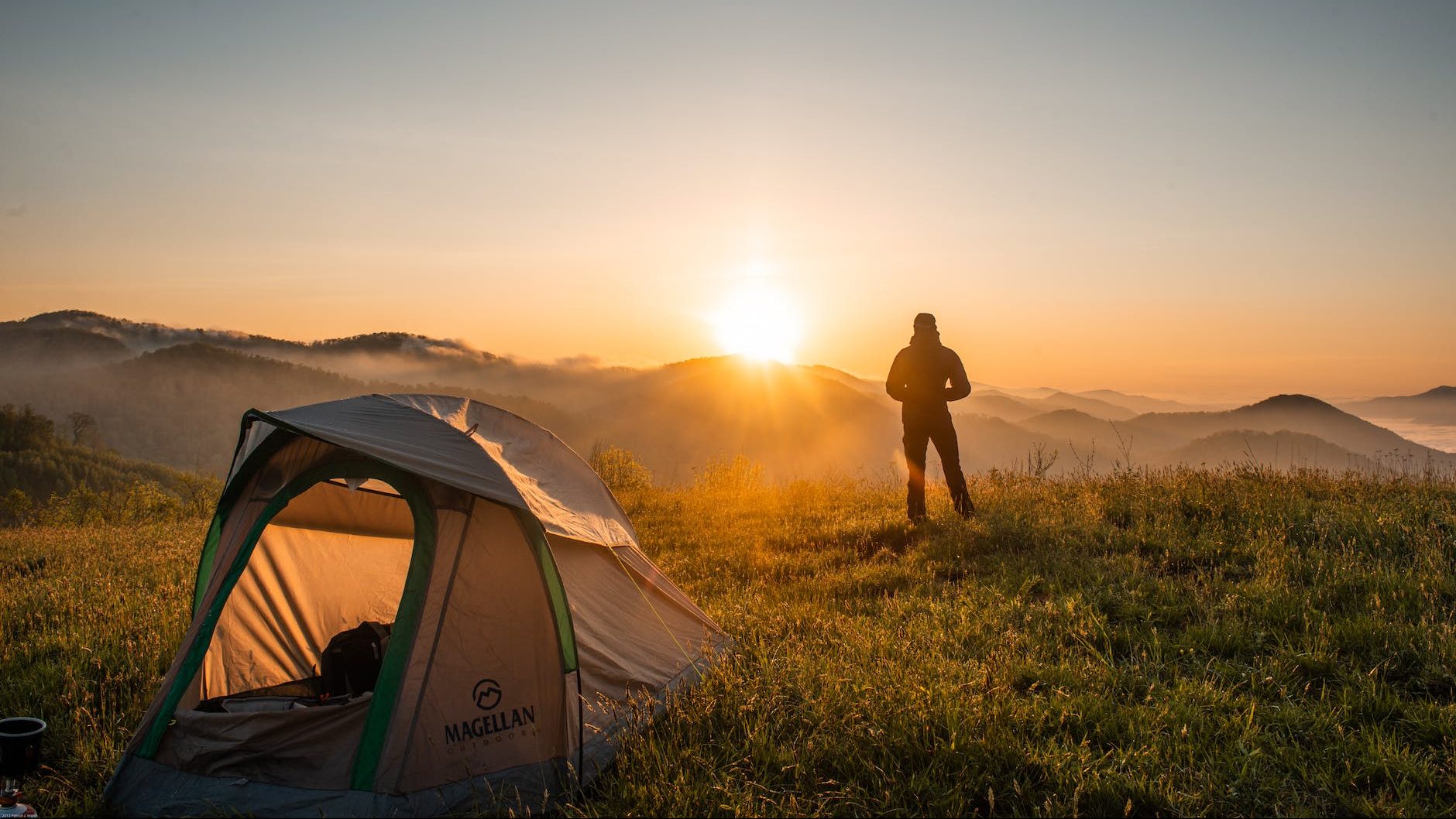 silhouette of person standing near camping tent