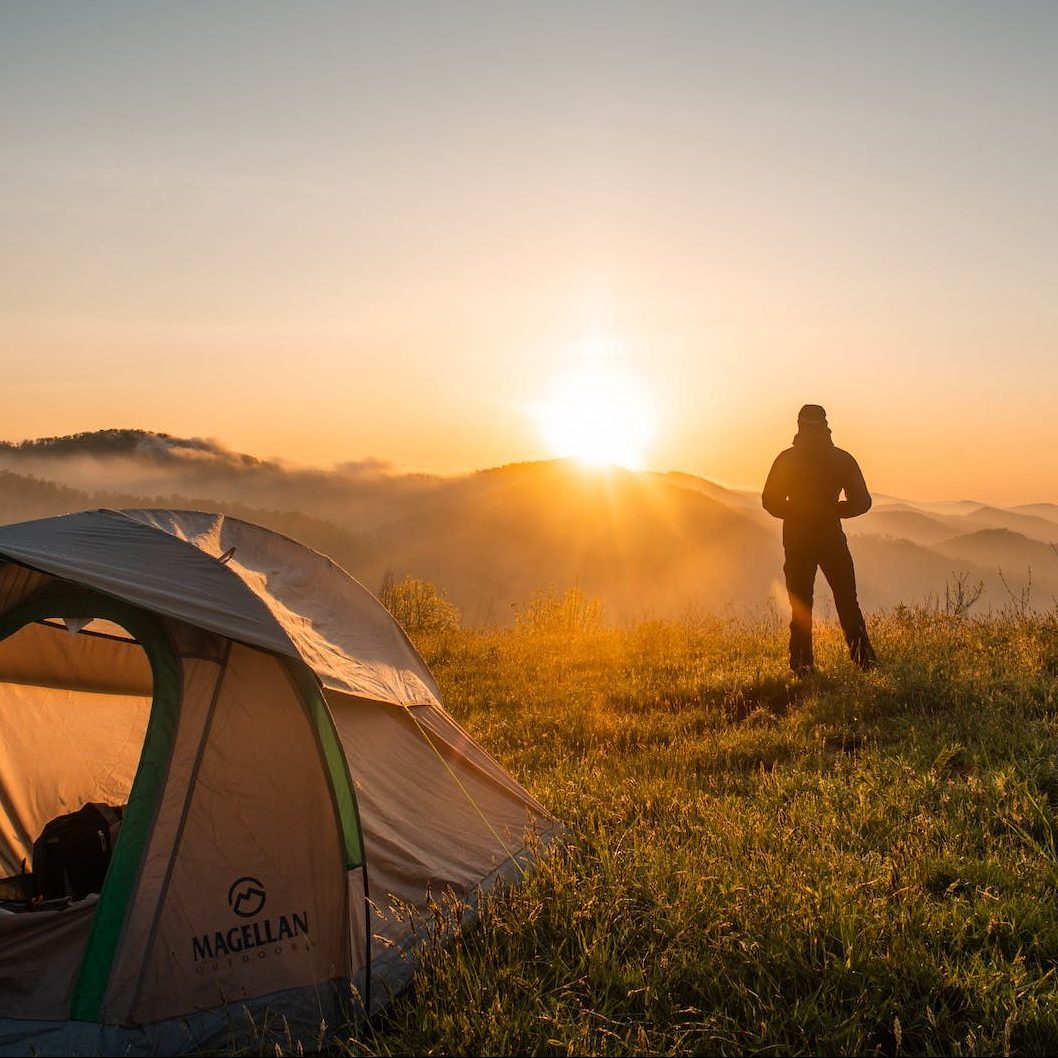 silhouette of person standing near camping tent